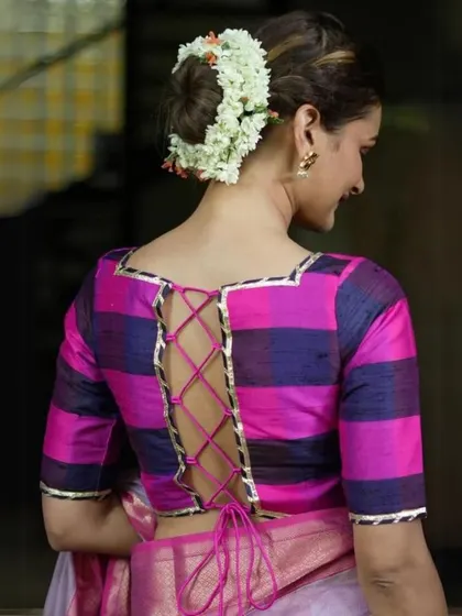 A bold checkered blouse in pink and blue with a corset-style tie-up back. This design is both modern and eye-catching.