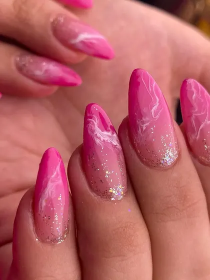 A beautiful pink marble effect with a touch of glitter. This design on long almond nails is a chic and trendy way to add some pattern and sparkle to your manicure.