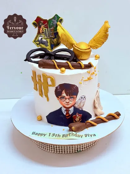 A detailed Harry Potter-themed cake featuring the Golden Snitch, a wand, glasses, and the HP logo. This cake is packed with iconic elements from the wizarding world.
