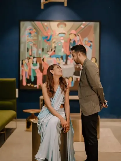 A candid moment between a couple at their cocktail party, set against a backdrop of modern art. We help select venues that match the desired aesthetic of your event.