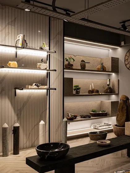 A wide shot of the product display area, showing how different shelving styles and lighting techniques are used to create visual rhythm. The combination of floating shelves and recessed, lit niches allows each product group to have its own moment.