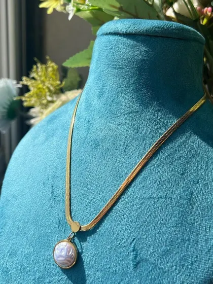A delicate snake chain necklace with a pearl-like pendant from Medusa House of Jewel.