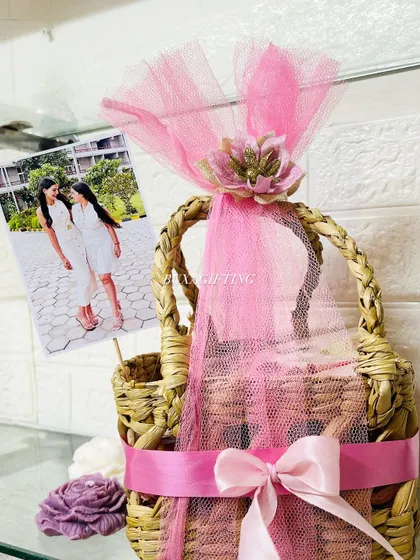 A beautiful hamper celebrating sisterhood and new beginnings, featuring a personalized photo, Lindt chocolates, and handwritten cards in a pink-themed jute basket.