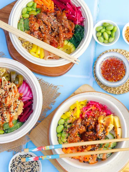 A colorful and fresh flatlay of poke bowls, styled to look like a healthy and fun picnic. This bright, airy style is perfect for brands targeting health-conscious consumers on social media and delivery platforms.
