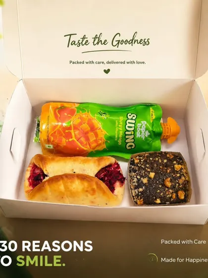 A filled veg bun, brownie and mango drink appear together in this display of a smaller snack combination we offer.