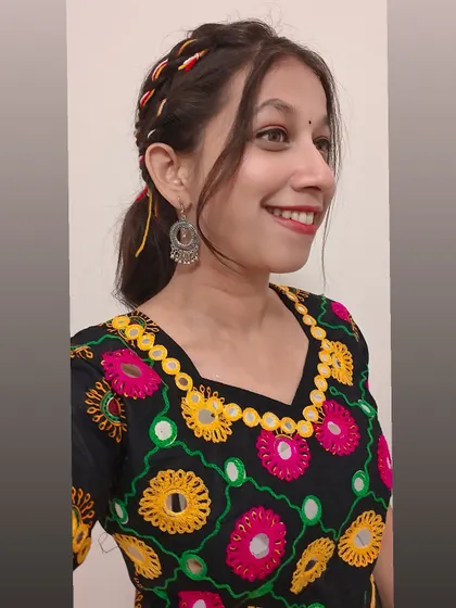 A smiling client with her unique braided ponytail. It's a playful and trendy look.