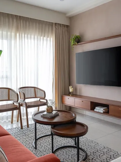 The living room in 'Living life in colours' features a peach textured wall and a teak TV unit, creating a warm and inviting atmosphere.