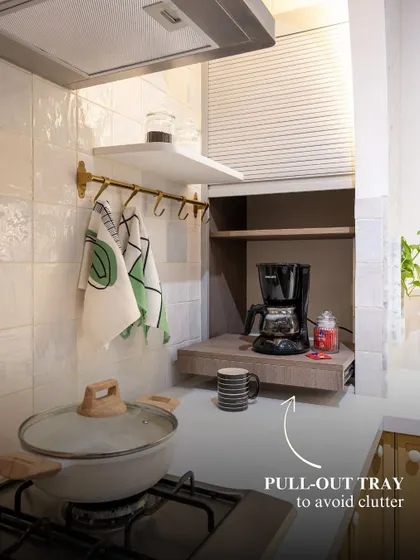 A simple pull-out tray can make a world of difference. This one creates a dedicated coffee station that can be neatly tucked away, avoiding clutter on the main countertop while keeping your morning ritual within easy reach.