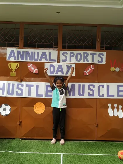 Arms raised in victory! This little Aster is thrilled to be part of our "Hustle Muscle" Annual Sports Day.