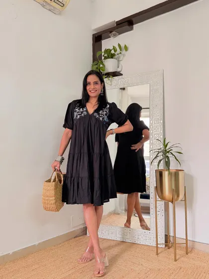 A cute black tiered dress with embroidery on the yoke. This is a versatile dress that can be styled for a day or night look.