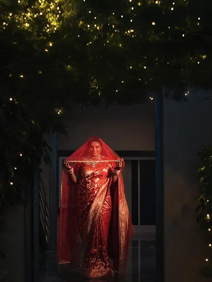 A bride making her entrance, framed by an arch of fairy lights. The dramatic lighting and her central placement make this a grand and magical moment.