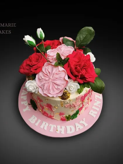 A birthday cake that looks like a bouquet of flowers. I arranged a variety of handmade sugar flowers, including roses and peonies, to create this vibrant and elegant floral display.