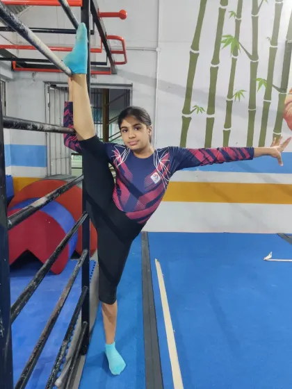With a look of pure determination, this gymnast holds a standing split. We encourage our students to push their boundaries while maintaining proper form.