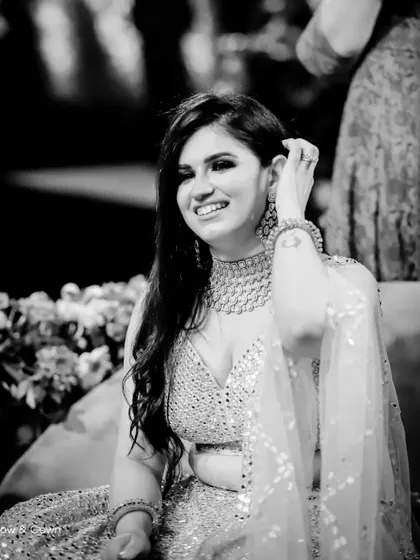 The black and white version of a candid engagement portrait. This edit focuses on her joyful expression and the beautiful details of her sparkling outfit.