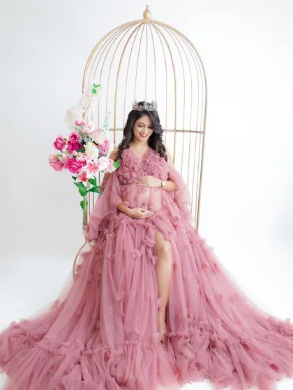 A fairytale moment for this queen. Seated in a golden birdcage chair, she looks radiant in a pink floral-detailed gown.