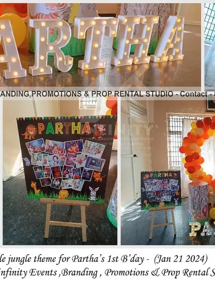 A simple jungle theme for a first birthday, featuring a transparent circular backdrop with a colorful balloon ring. The setup also includes multiple milestone and photo boards, making it a highly personalized celebration.