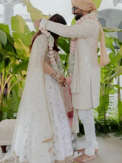 The groom places the garland on his bride, a playful and significant part of the wedding ceremony.