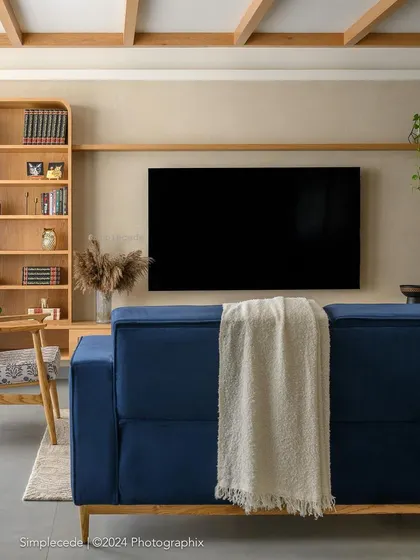 After: The same wall, now featuring a curved arch framing the TV and a custom bookshelf, adding architectural interest and a soft, contemporary feel to the space.