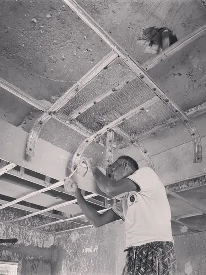 A craftsman meticulously shaping the framework for a curved ceiling. This level of hands-on skill is essential to bringing our more complex geometric designs to life.