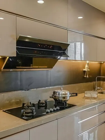 A close-up of the hob and chimney in the acrylic parallel kitchen, highlighting the clean lines and modern appliances.