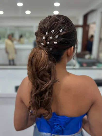 A modern and chic textured ponytail with crystal accents. This style is perfect for a glamorous evening event.