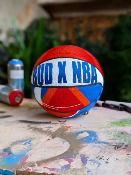 The custom basketball on my paint-splattered work table, with spray cans in the background. This is where the magic happens.