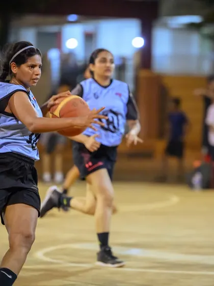 A women's player on a fast break, pushing the ball up the court with speed and control.