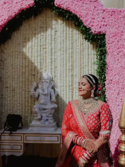Seeking blessings on her special day. This candid shot shows the bride in a serene moment, her traditional makeup looking flawless even in the bright sunlight.