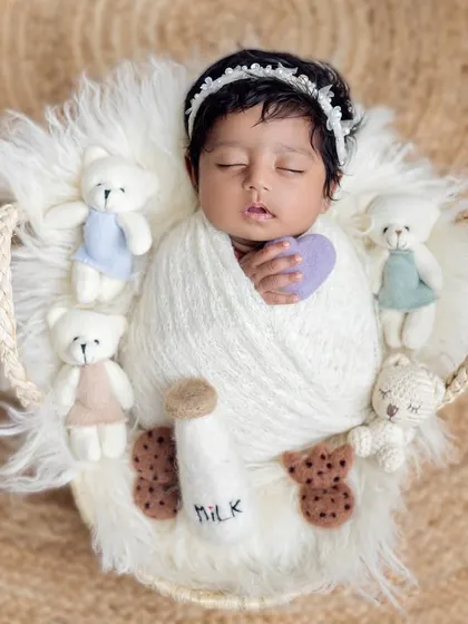 Milk and cookies time! This adorable setup features a newborn in a basket with teddy bears, a prop milk bottle, and felt cookies for a sweet and playful theme.