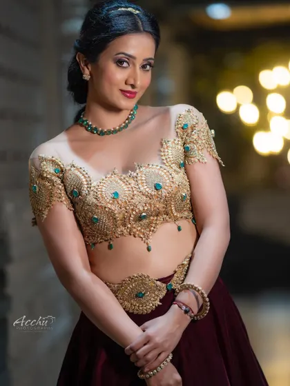 An opulent and detailed ethnic look. This portrait focuses on the intricate gold embroidery of the blouse and the rich color of the lehenga, perfect for a bridal or festive shoot.
