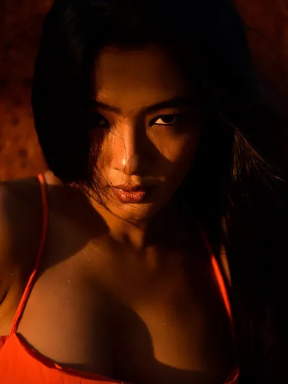 An intense and powerful close-up. The deep shadows and direct gaze create a feeling of mystery and confidence.