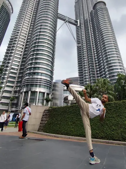 A high kick in front of the Petronas Twin Towers in Kuala Lumpur. Martial arts is an adventure, and I take my practice with me wherever I go.