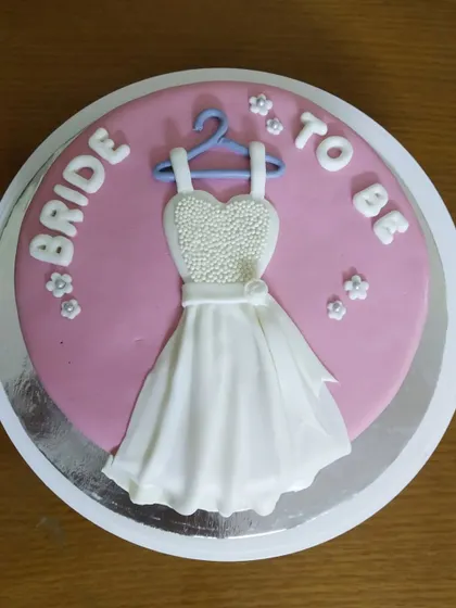 A sweet and simple "Bride to Be" cake. The centerpiece is a handcrafted fondant wedding dress, perfect for a bridal shower or bachelorette party.