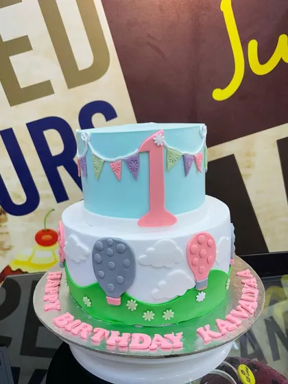 A lovely 3kg two-tiered first birthday cake with a hot air balloon theme.