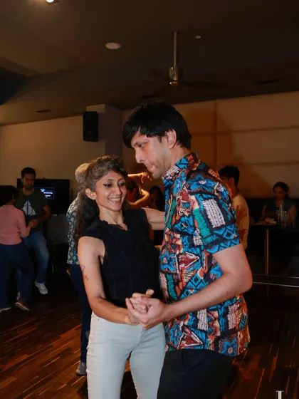 A couple smiling as they dance together. The man's colorful shirt adds to the fun, festive vibe of Havana Nights.