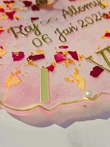 Another angle of the custom 10-inch varmala wall clock, showing the glossy finish and the depth of the preserved rose petals and gold flakes.