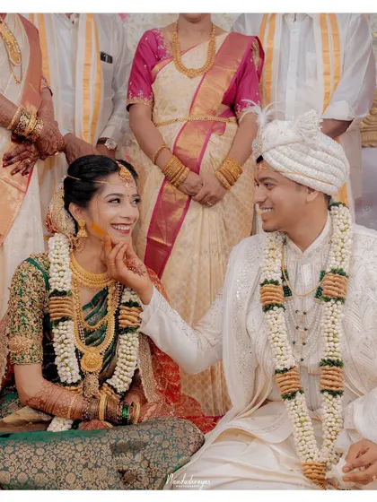 A playful and loving touch during the ceremony. This candid shot captures the couple's chemistry and the joy they find in each other's company.