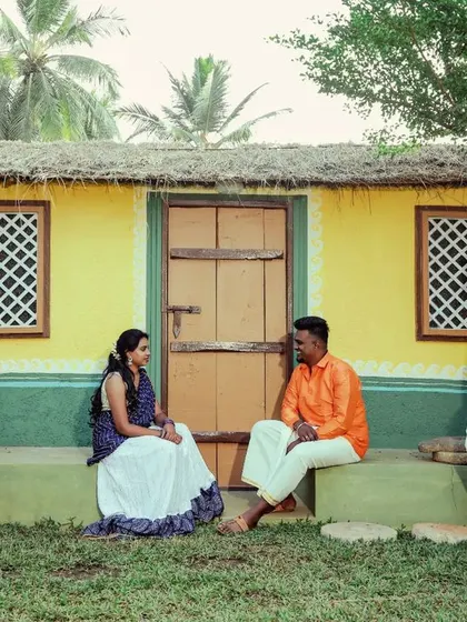 A candid group shot of friends or family in traditional attire, relaxing in a village setting. It captures a sense of community and celebration.