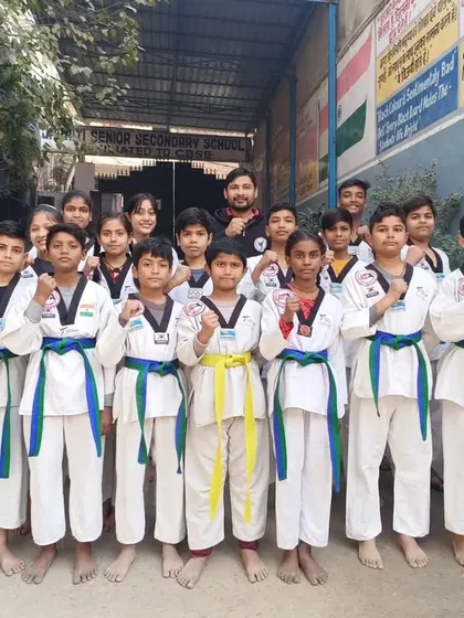 A group of our students proudly wearing their new blue and green belts after the color belt distribution ceremony.
