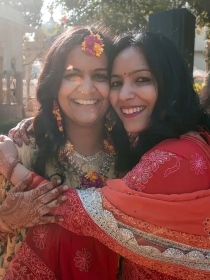 A warm hug between friends or family at the haldi ceremony, capturing the love and support surrounding the couple.