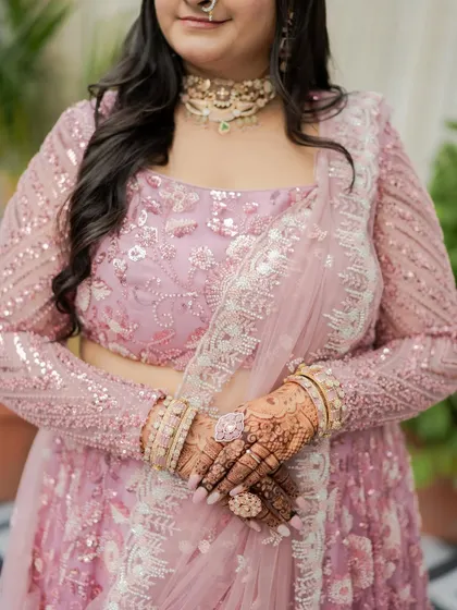 This shot highlights the details of her hands and henna, with the soft makeup look providing a perfect, non-distracting backdrop.