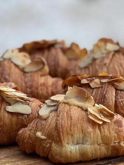 Flaky, buttery almond croissants, perfect for a breakfast meeting or a high-tea event.