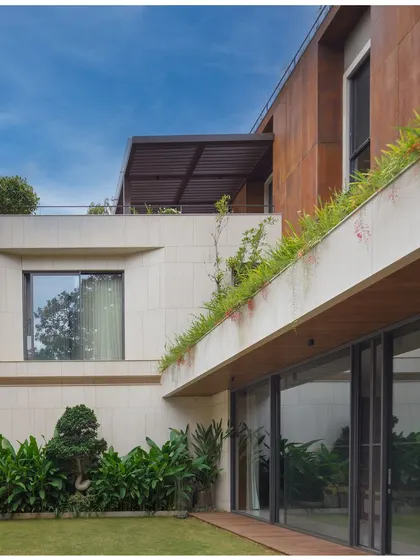 The U-L-I Residence features a lush courtyard garden that seamlessly integrates with the living spaces. The design uses planters along the building edge and large sliding glass doors to blur the boundary between inside and out.