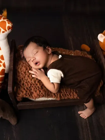 Surrounded by his favorite stuffed animal friends, this little one is sleeping peacefully. I use soft toys to add a touch of whimsy to my newborn photography.