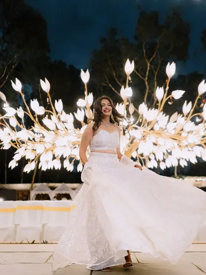 The bride looks radiant in front of the tree of light, a unique decor piece that we designed to create a magical and artistic photo opportunity.