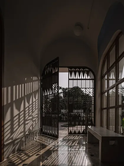 The play of light and shadow from the custom-designed safety door creates a beautiful, graphic pattern on the floor and walls of the vestibule.