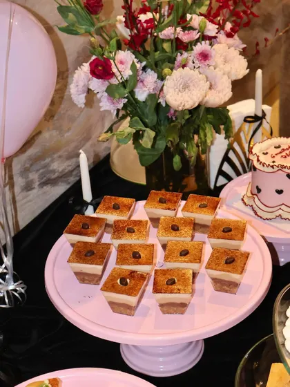 Our individual Tiramisu dessert cups are a party favorite. Here they are beautifully arranged on a pink cake stand, each topped with a coffee bean, ready for guests to enjoy.
