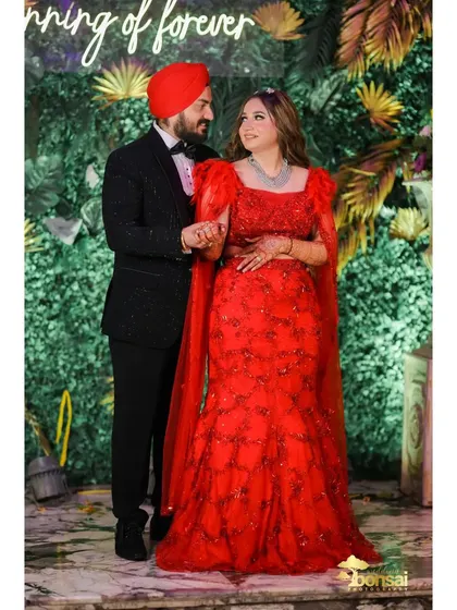 A full-length portrait of the couple against a beautiful floral backdrop.