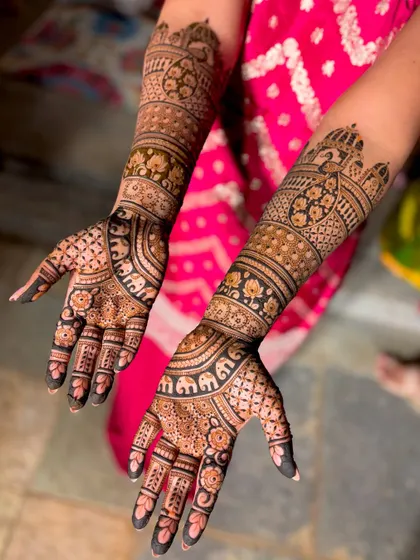 An intricate bridal design featuring rows of elephants and detailed floral and geometric bands.