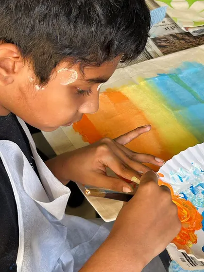 This young artist is concentrating on his sunset-themed tote bag. I love seeing the creativity and focus from kids in my workshops.